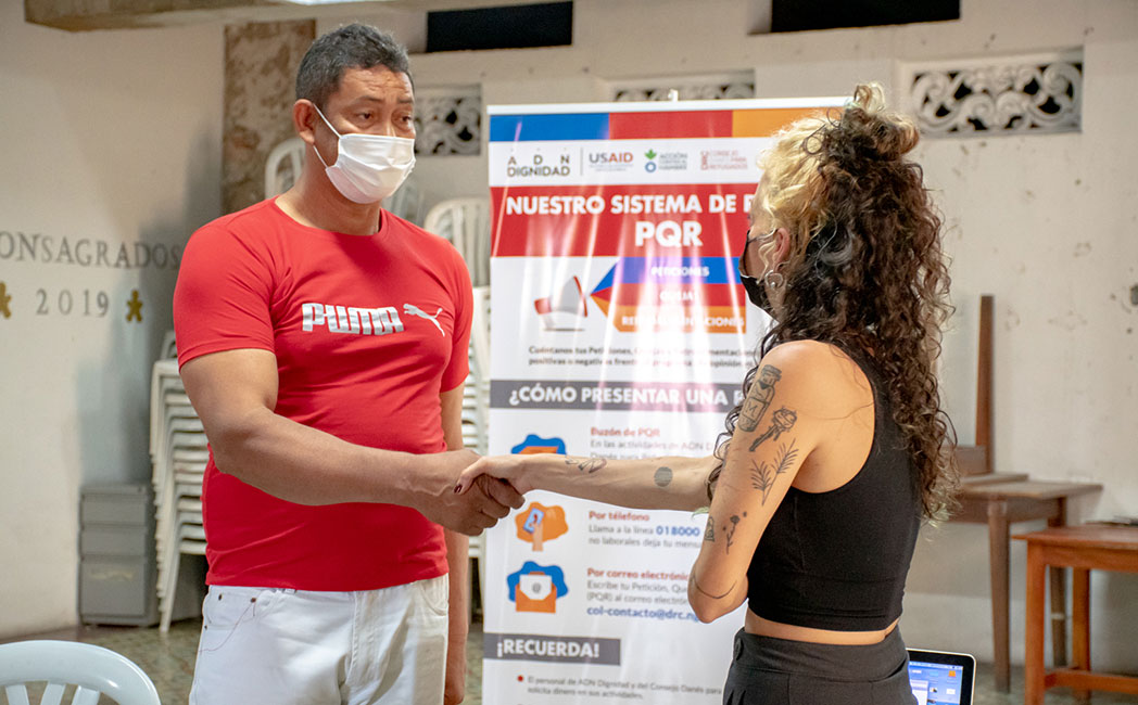 A man and a woman shake hands at one of our projects in Colombia.