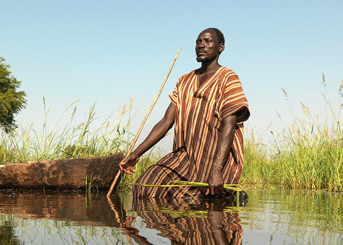 Gai tries to spear fish after his village in South Sudan is flooded, showing resilience in the face of hunger caused by climate change.