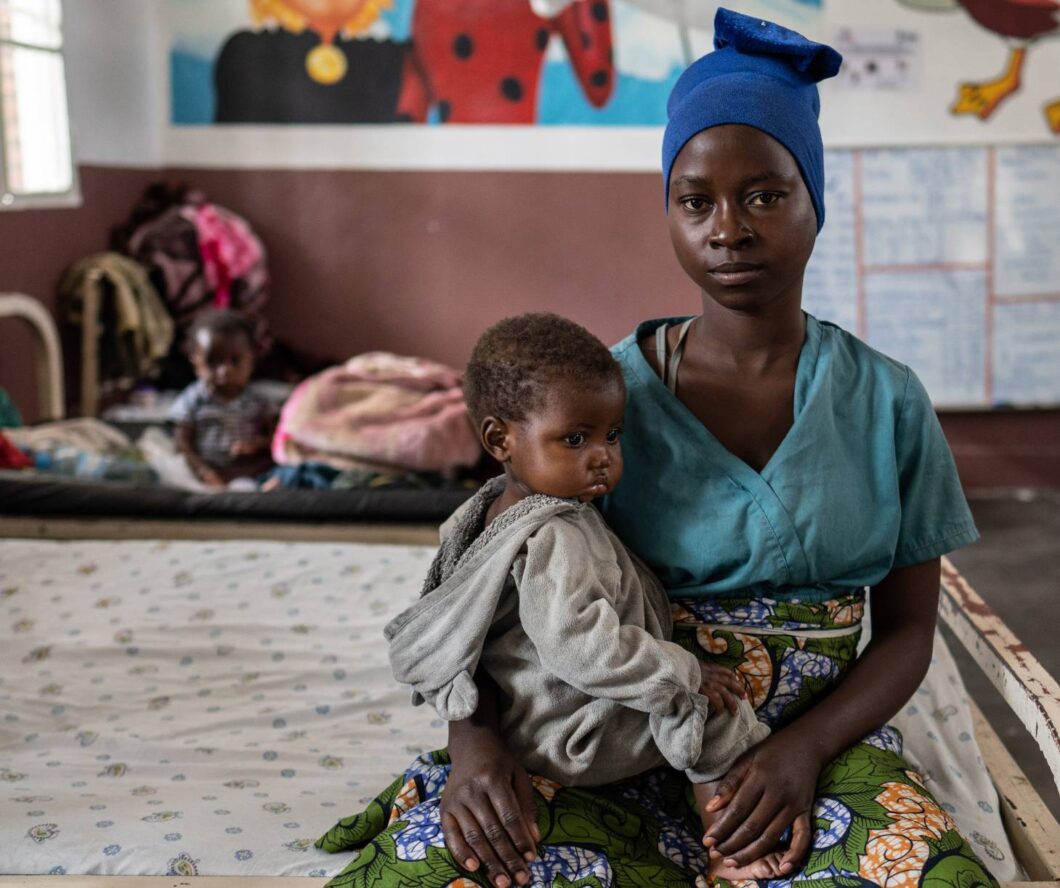 Woman in Congo holding her child in malnutrition treatment centre.
