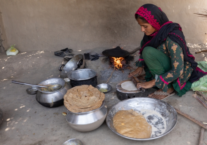 Woman cooking food with Action Against Hunger cooking kit.