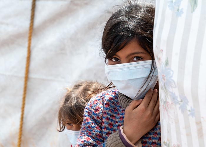 Bushra wears a mask in Al-Harakat Camp in Idlib, Syria.