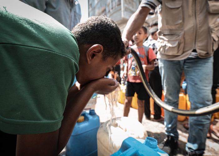 Boy in Gaza drinks water from water aid provided by Gaza Appeal.