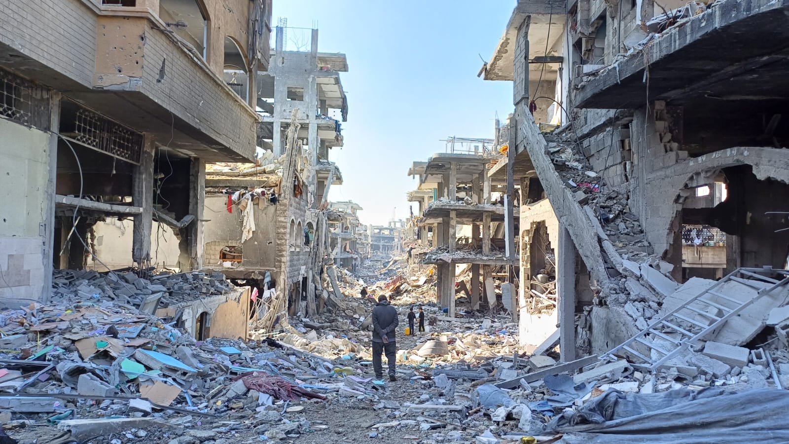 Palestinian standing in rubble of Gaza.