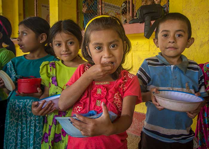 A girl eating food at an Action Against Hunger project in Guatemala.