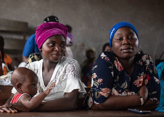 Esther with her eight-month-old daughter and Micheline during a mental health session at a school in Kichanga, DR Congo.