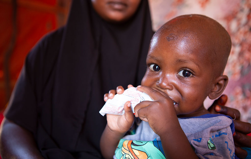 Mohamed eats ready-to-use therapeutic food provided by Action Against Hunger at his home in Mogadishu, Somalia.