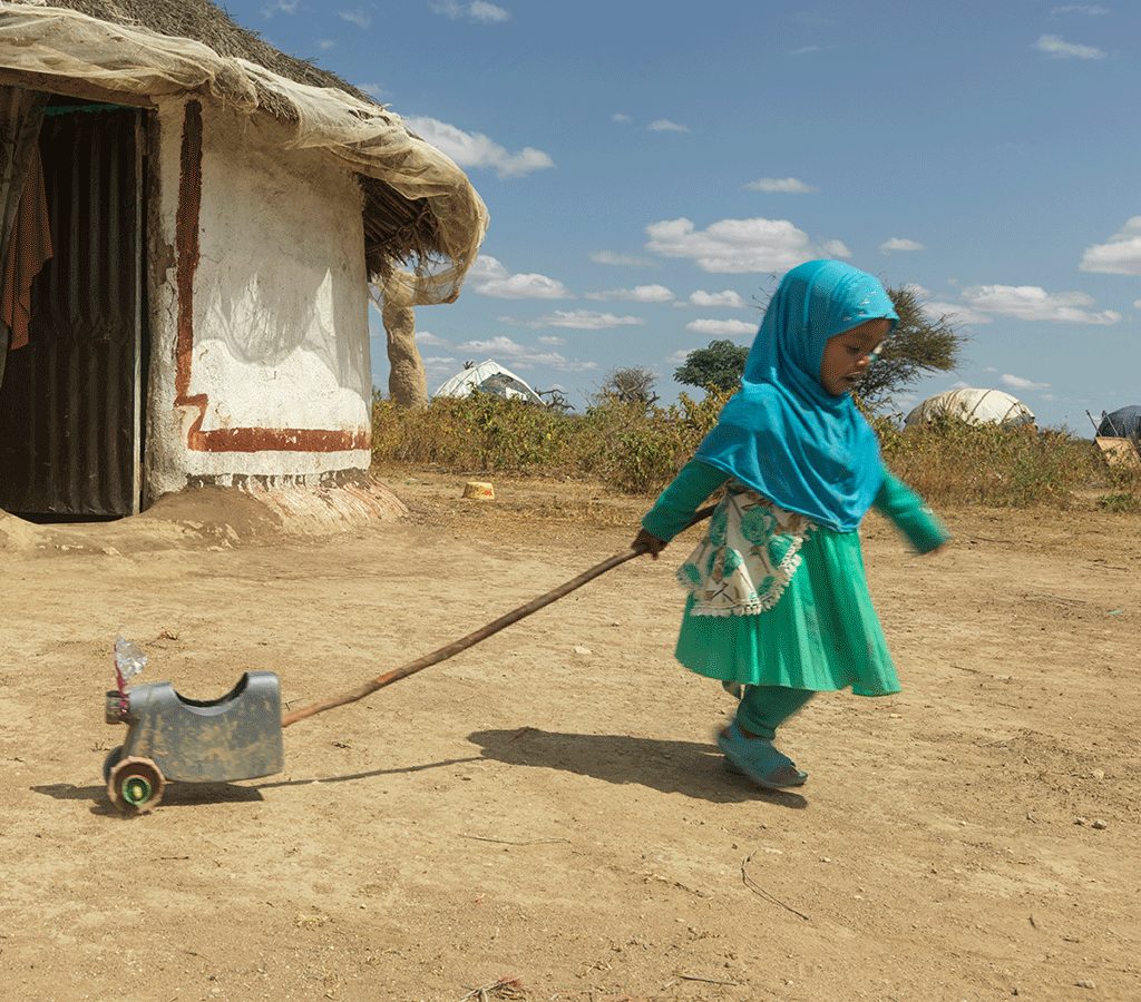 After recovering from malnutrition,Munira plays with her toy outside her house in Ethiopia