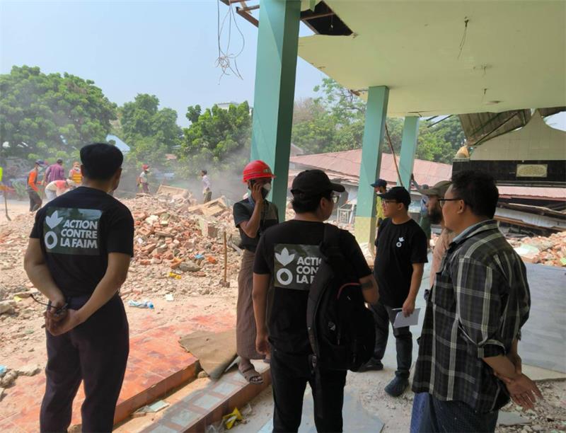 Action Against Hunger staff meet the local community at a mosque destroyed by the earthquakes in Myanmar.