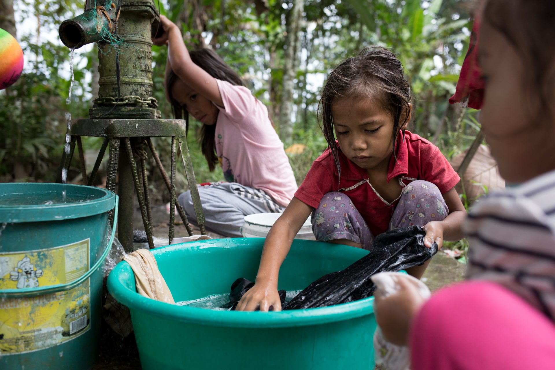 A young girl in South Sudan with her hand in water.