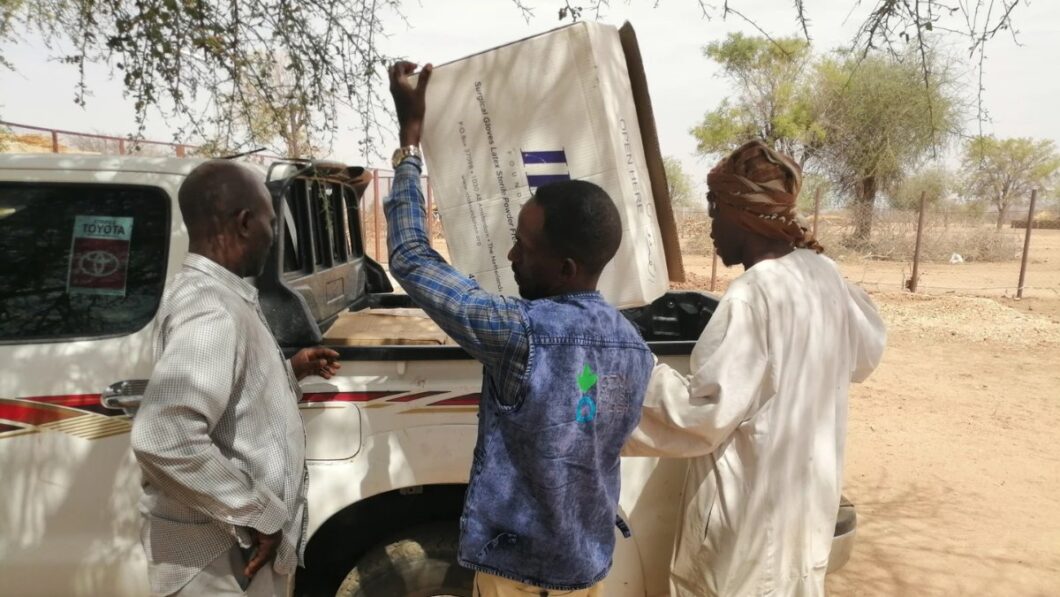 Two Action Against Aid working taking medical supplies off aid truck.