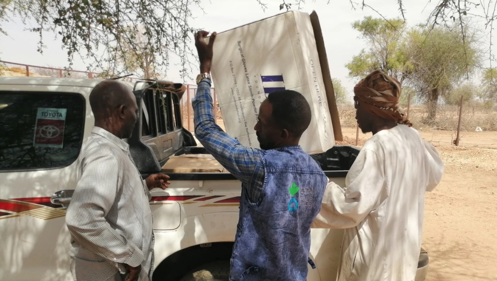 Two Action Against Aid working taking medical supplies off aid truck.