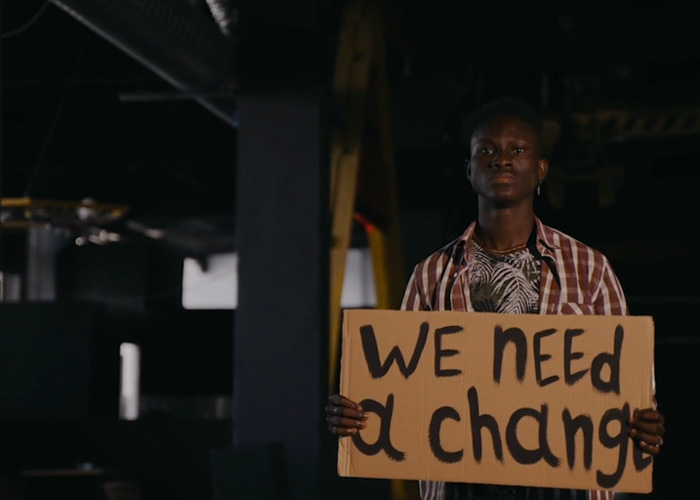 A man holds up a sign saying 