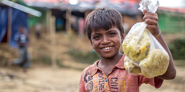 Muk collects a bag of rice at an Action Against Hunger distribution centre in Bangladesh.