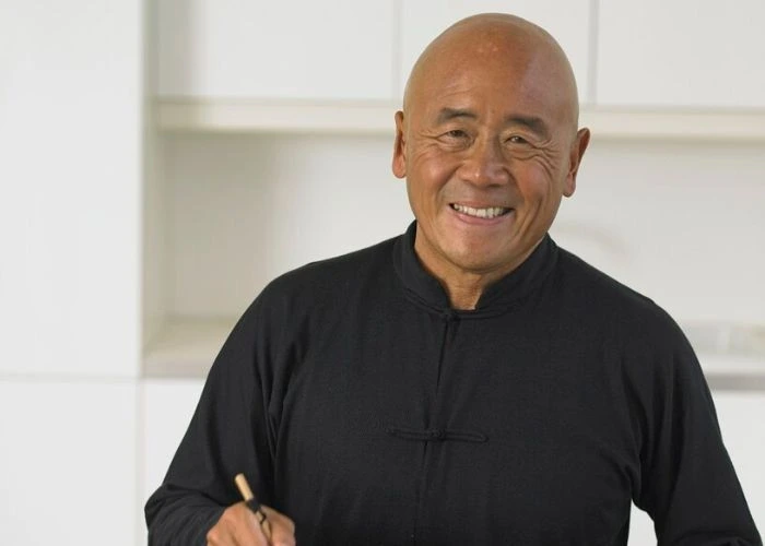 Ken Hom smiling in kitchen.